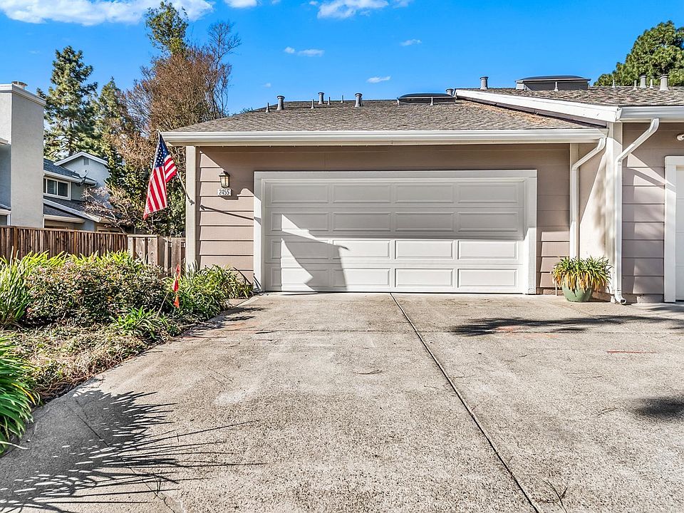Suburban house in San Leandro CA, front exterior with white garage door and driveway
